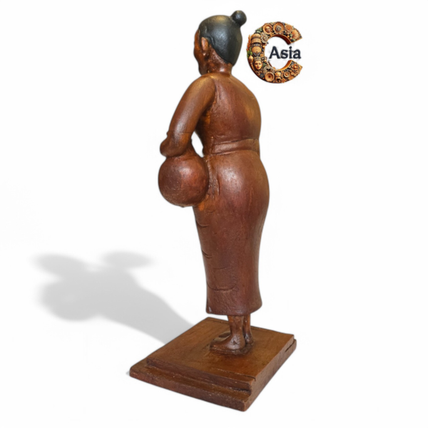 Angled rear view of vintage wooden village woman figurine showing hand-carved detail and natural wood grain