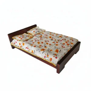 Handcrafted wooden doll bed with floral bedding on a white background